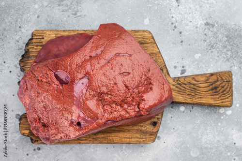 Obraz na plátně Raw lamb liver on wooden cutting board with fork, fresh sheep offal, rustic back