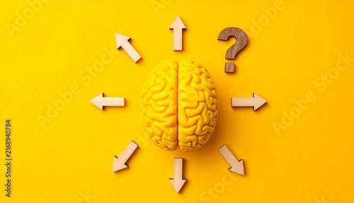 Yellow Human Brain Model with Wooden Question Mark Surrounded by Inward Wooden Arrows on Bright Yellow Background