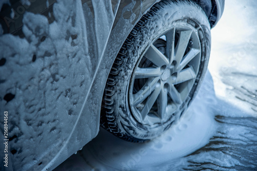 Konstfotografi Close-up of a car alloy wheel and tire covered with thick foam during rim cleani
