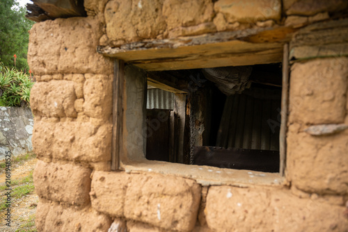 Close-up view of a rustic adobe wall window in a traditional rural building in Hidalgo, Mexico.