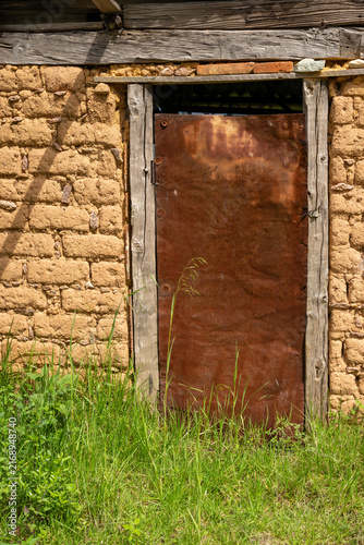 Vertical view of a rustic storage door on an adobe house in rural Hidalgo, Mexico.