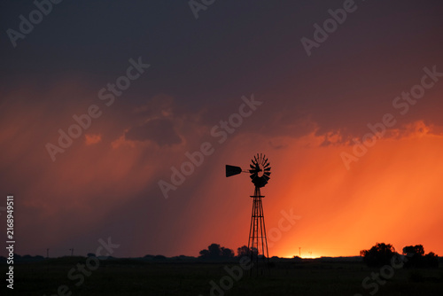 Windmill at sunset with a rain storm in the background, Pampas, Patagonia,Argentina.