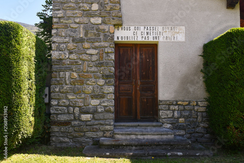 Фотография Rustic stone secondary entrance and wooden door of a historic cemetery with a tr