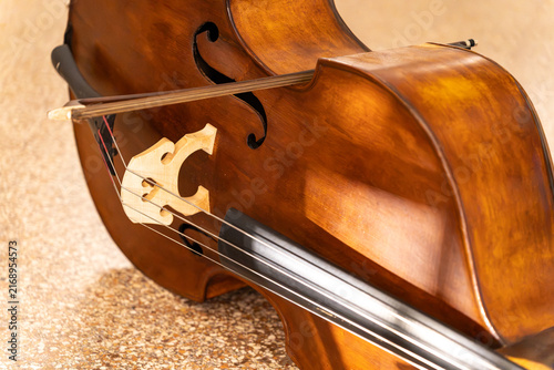 Foto Detailed view of a classic double bass body with a bow resting on the strings