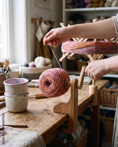 Fiber artist winding hand-dyed gradient yarn into a center-pull ball