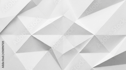 Abstract white paper texture with folded geometric triangles creating a modern minimalist background for creative graphic design projects