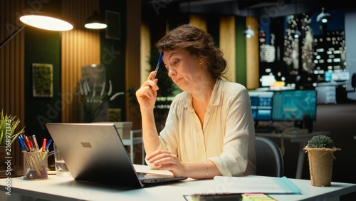 Obraz na płótnie Career-driven businesswoman reflects on and envisions a new concept to develop company activity, searching for solutions and new ideas while a tactical worker plans objectives after hours in office