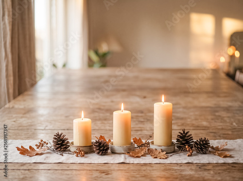 Autumnal Glow: Three pillar candles illuminate a rustic wooden table adorned with a runner, scattered pinecones, and fallen autumn leaves, creating a warm and inviting ambiance.
