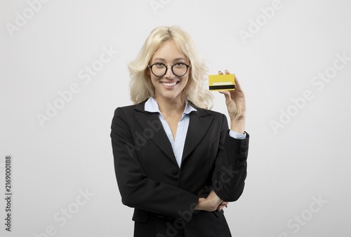 Foto Smiling Young Caucasian Woman Holding Credit Card In Modern Office Setting, Looking Confident And Engaged In Financial Transaction, Showing Enthusiasm For Business Opportunities