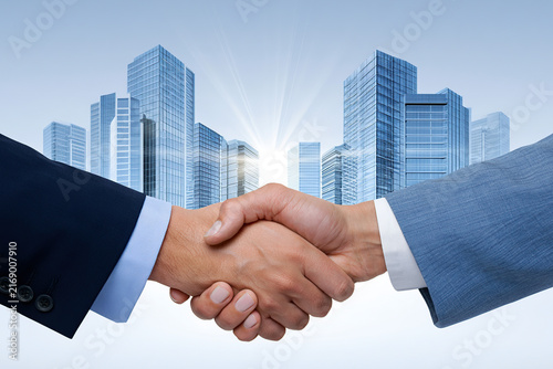 Handshake with a background of corporate buildings and sunbeams