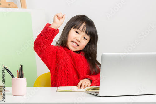 Konstfotografi Intelligent Chinese girl doing homework at desk, thinking deeply and having a great idea or eureka moment