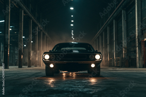 Cinematic muscle car parked in industrial warehouse