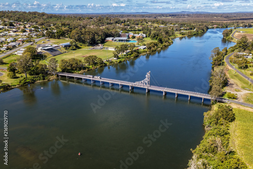 Aerial view of the bridge crossing the Clarence River at Maclean, showing the broad river, transport infrastructure and surrounding town and rural landscape in the Northern Rivers