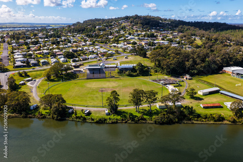 Aerial view of Maclean Showground beside the Clarence River, with the town of Maclean and surrounding rural landscape visible in the background in the Northern Rivers region of NSW, Australia.