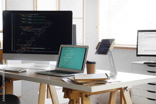 Programmers workplace with gadgets in office