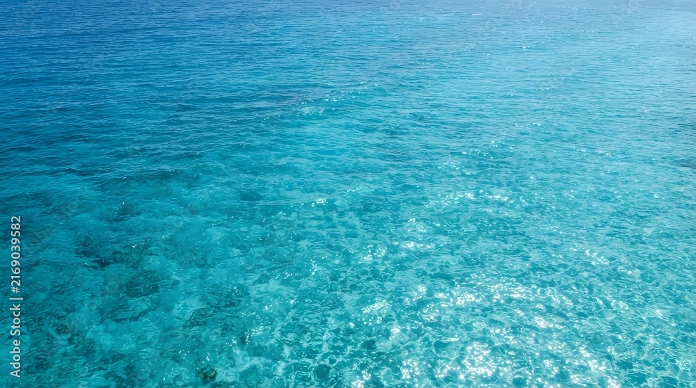 Obraz premium Aerial view of clear turquoise ocean water surface with sun glint and gentle ripples