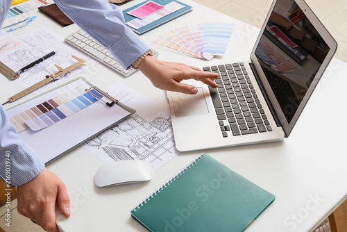 Female interior designers hands working with laptop at table in office