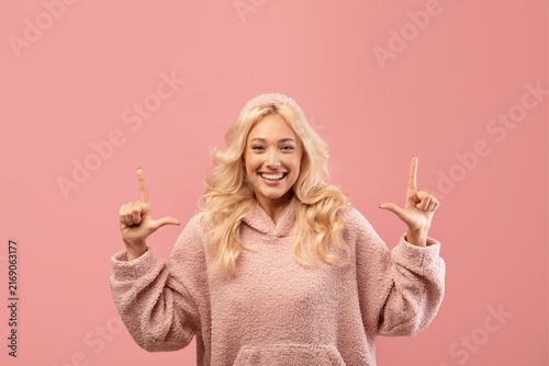 Canvas Print Smiling Young Woman With Joyful Emotion Gesturing With Hands At Studio With Pink Background, Conveying Happiness And Positivity