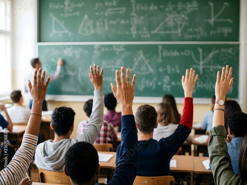 Engaged students eagerly raising hands in a lively classroom with chalkboard filled with geometric diagrams and equations