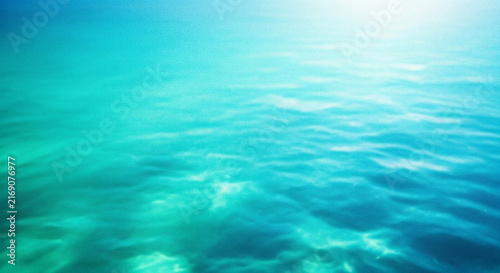 A serene and abstract view of turquoise water with subtle wave patterns and bright highlights