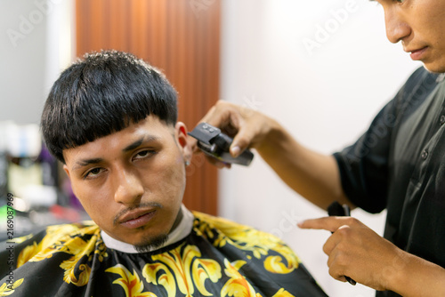 Obraz na płótnie Barbershop client getting a fresh haircut from barber