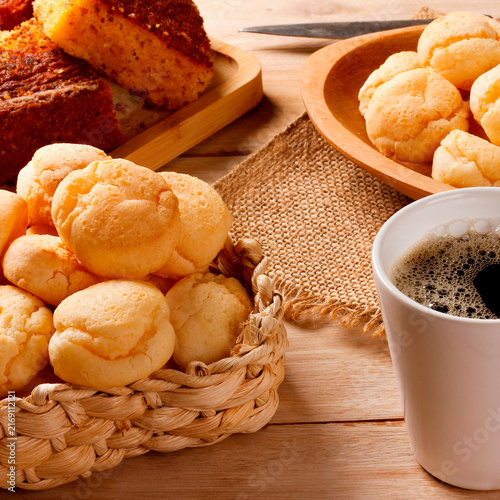 Brazilian breakfast with fresh black coffee and homemade cheese bread served in rustic baskets and platters, accompanied by corn cake.