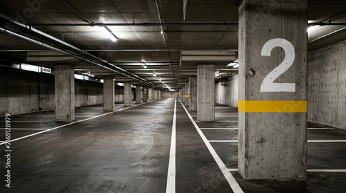 Empty underground parking garage with concrete pillars and marked spaces