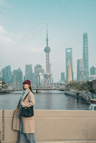 Canvas Print Traveler in a maroon cap pauses on the promenade by Zhapu Bridge, Shanghai