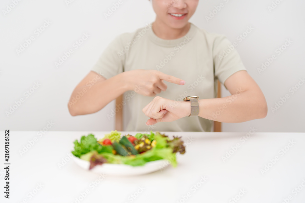 Naklejka premium happy smiling woman with fresh organic vegetables plate and checking time. intermittent fasting, IF, nutrition control, weight loss, clean eating, Healthy food eating, Wellness, dieting and lifestyle