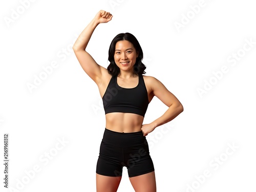 A smiling fit asian woman in black activewear celebrating with a raised arm
