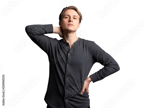 A confident young man posing in a dark long sleeved shirt against white