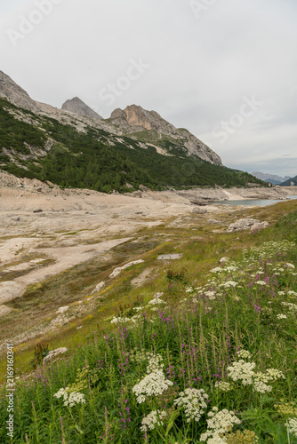 Canazei, Italy. Exposed shoreline and low water level at Lago di Fedaia showing drought conditions in the Dolomites