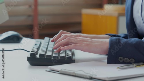 Businesswoman hands typing on computer keyboard at office desk