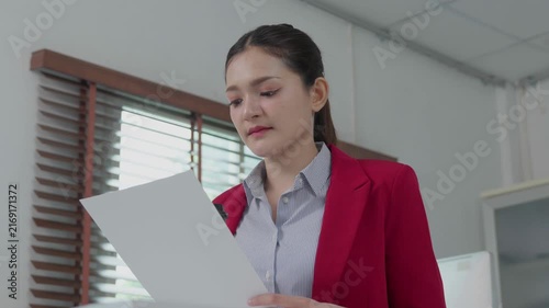 Asian businesswoman reading corporate document in office