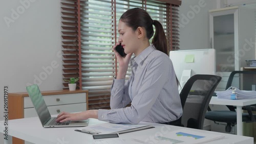 Asian businesswoman multitasking in modern office workplace