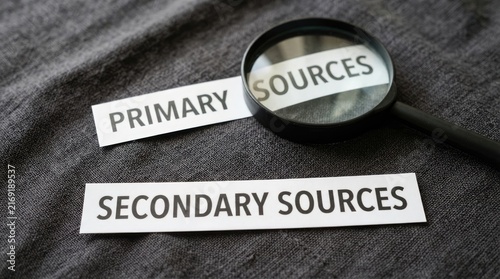 Foto Primary sources and secondary sources text labels, magnifying glass on academic