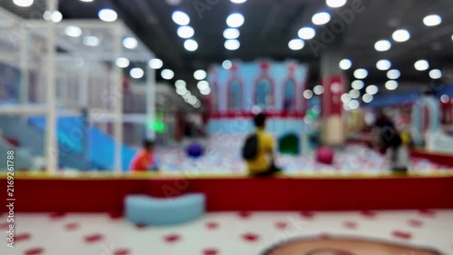 Abstract blurred interior view of colorful indoor children playground with bokeh lights.
