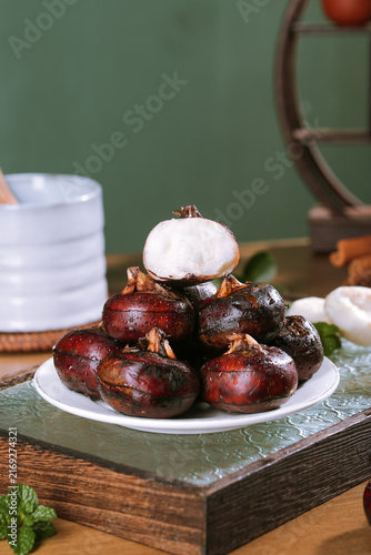 Fresh Roasted Chestnuts with Cream on Rustic Farmhouse Table Red Background