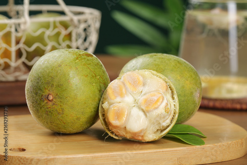 Fresh Luo Han Guo Monk Fruit Cut Open on Wooden Board Showing Natural White Flesh Segments