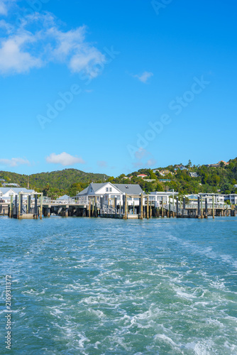 Water trails behind ferry leaving Paihia waterfront.