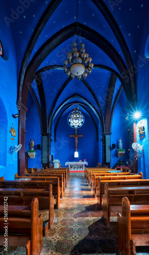 Fotografie Blue church interior with wooden pews and altar