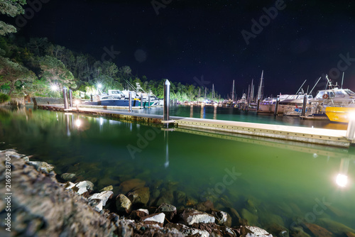 Boats in marina at night with starry sky overhead in Tutukaka