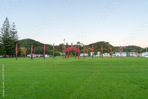 Carved red pou (posts) standing in a grassy field Located near Waitangi and Paihia in the Bay of Islands