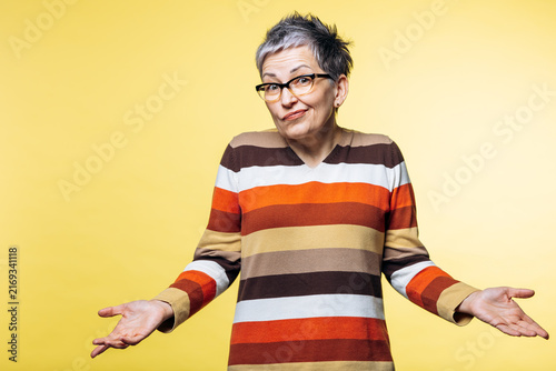 Fotografie Woman shrugging with open hands, expressing confusion and uncertainty against a
