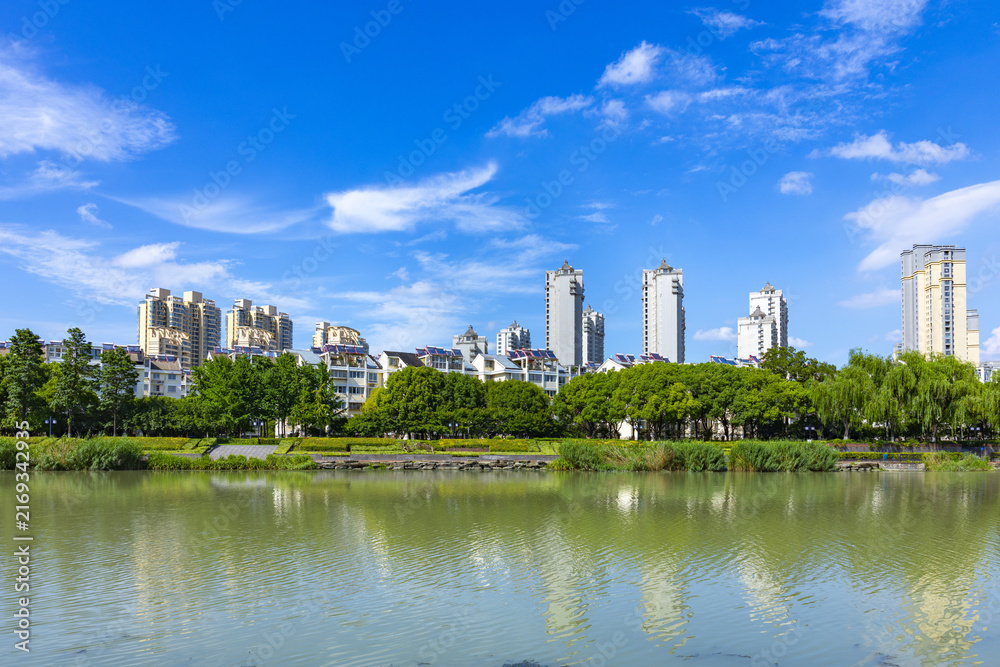 Fototapeta premium Modern lakeside residential skyline under blue summer sky