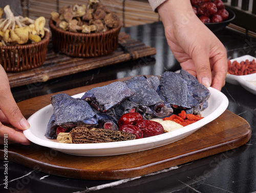 Fotografie Hands Placing Traditional Chinese Herbal Ingredients on a Serving Platter