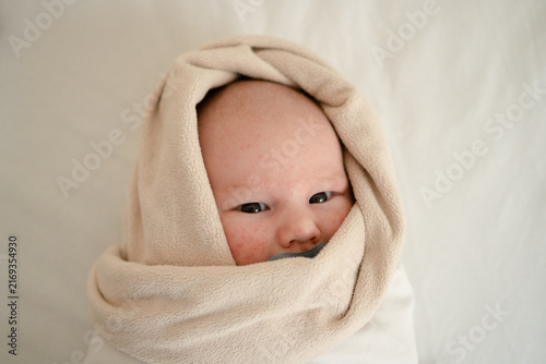 Bild auf Leinwand A swaddled newborn with a pacifier sleeps calmly indoors, wrapped tightly in a white blanket for better sleep
