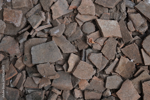 Broken terracotta clay shards background, shattered ceramic pottery pieces texture.
