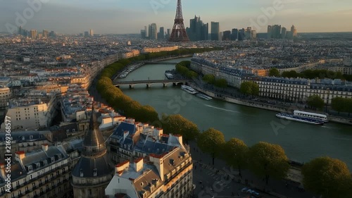 Panoramic aerial view of Paris cityscape along the Seine River at sunset.