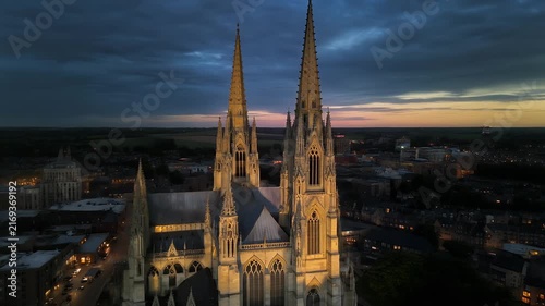 Aerial view of a grand cathedral at dusk with dramatic sky.